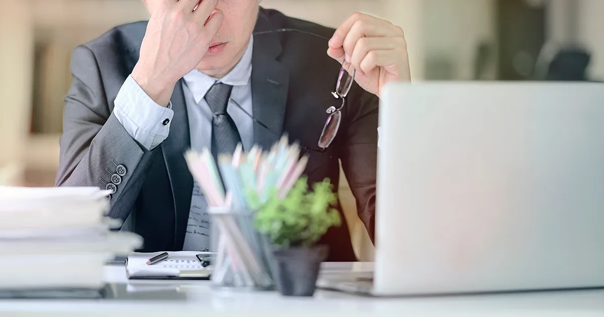 頭を抱えているビジネスマンの画像